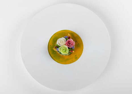Gourmetgericht mit drei essbaren Rosen auf gelber Sauce, kunstvoll angerichtet von Einstein Gourmet aus der Ostschweiz- Einstein St.Gallen